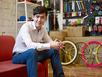 Portrait of young man sitting in bike shop