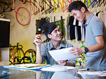 Two young men with paperwork in bike shop