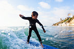 Young boy surfing wave, Encinitas, California, USA