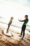 Mother and daughter practicing on surfboard, Encinitas, California, USA