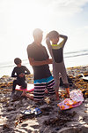 Father and children preparing to surf, Encinitas, California, USA