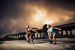 Man and woman training with kettlebells on gymnasium rooftop