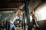 Men training on exercise bar in gymnasium