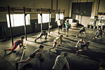 Fitness class training and stretching together in gym