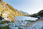 Young man camping at remote lake, Trinity Alps, California, USA