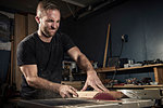 Male carpenter using a rotary saw in workshop