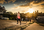 Team of runners running up a steep city hill