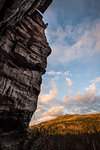 Silhouette of rock climber at the top of a 35m rock cliff at the Boulder Fields in the South Okanagan Valley, Kelowna, British Columbia, Canada