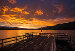 Young woman jumping off Wharf Park into Okanagan Lake in the South Okanagan Valley, Naramata, British Columbia, Canada