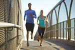 Man and woman running over bridge