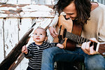 Father entertaining son with guitar