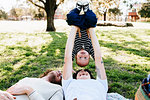 Couple with baby on picnic blanket in park