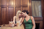 Two women face to face sharing intimacy in cafe