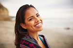 Portrait of smiling young woman wrapped in towel on beach, San Diego, California, USA