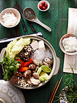 Still life of vegetable nabe with bowls of rice