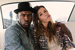 Portrait of couple pulling faces in back seat of car