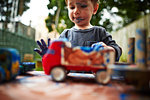 Boy playing with toy trucks and watercolour