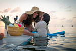 Romantic couple preparing cocktails on paddleboard, Islamorada, Florida, USA
