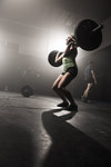 Mid adult woman lifting barbell