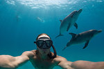 Man free diving with Atlantic spotted dolphins, Bimini, Bahamas