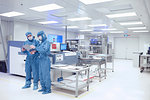 Male worker having discussion in flexible electronics factory clean room