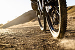 Cropped surface view of young man mountain biking on dusty dirt track, Mount Diablo, Bay Area, California, USA