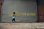 Young female runner running on city street