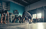 Surface level view of crossfitters exercising together in gym