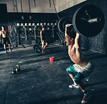 Male crossfitter shouting whilst lifting barbell in gym