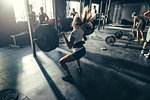 Female crossfitter training with barbell in gym