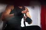 Female boxer putting on handwrap