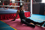 Female boxer resting in gym