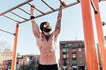 Man using horizontal ladder in outdoor gym