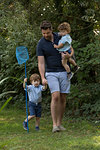 Father and children with fishing net in park