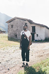 Cool young man in dungarees by farm building, portrait, Primaluna, Trentino-Alto Adige, Italy