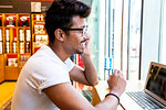 Man using laptop in cafe