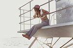 Woman relaxing on lifeguard tower