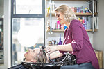 Hairdresser rinsing customer's hair in salon