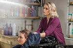 Hairdresser drying customer's hair in salon