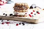 Stacked cookie with cream and caramel on chopping board, still life