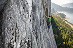 Young female rock climber climbing up rock face, elevated view, The Chief, Squamish, British Columbia, Canada