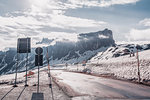 Rural road in snow capped mountains, Dolomites, Italy