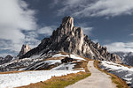 Dirt track in snow capped mountains, Dolomites, Italy