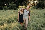 Romantic young woman and boyfriend strolling in field of long grass