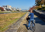 Cycling along the bank of the Kamo River in autumn, Kyoto, Japan, Asia