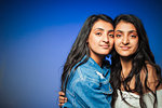 Portrait confident teenage twin sisters hugging
