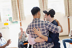 Men hugging in group therapy