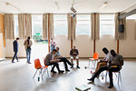 Men waiting, using smart phones in community center