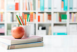 Student's desk with books, colored pencils and a snack, back to school and creativity concept