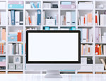 Professional creative workspace with computer on a white desktop and colorful folders on the shelves